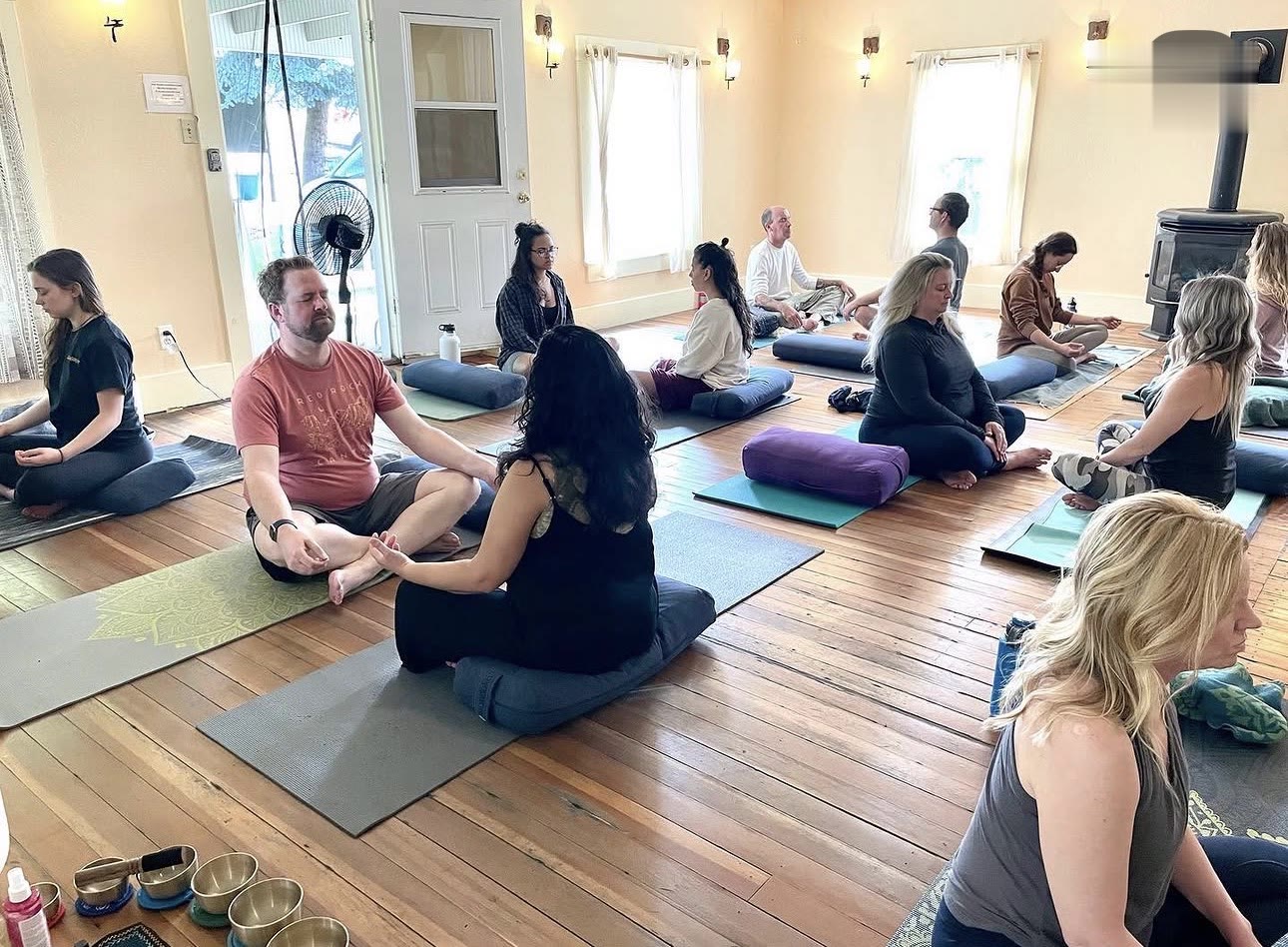 A seated meditation class in the warm studio