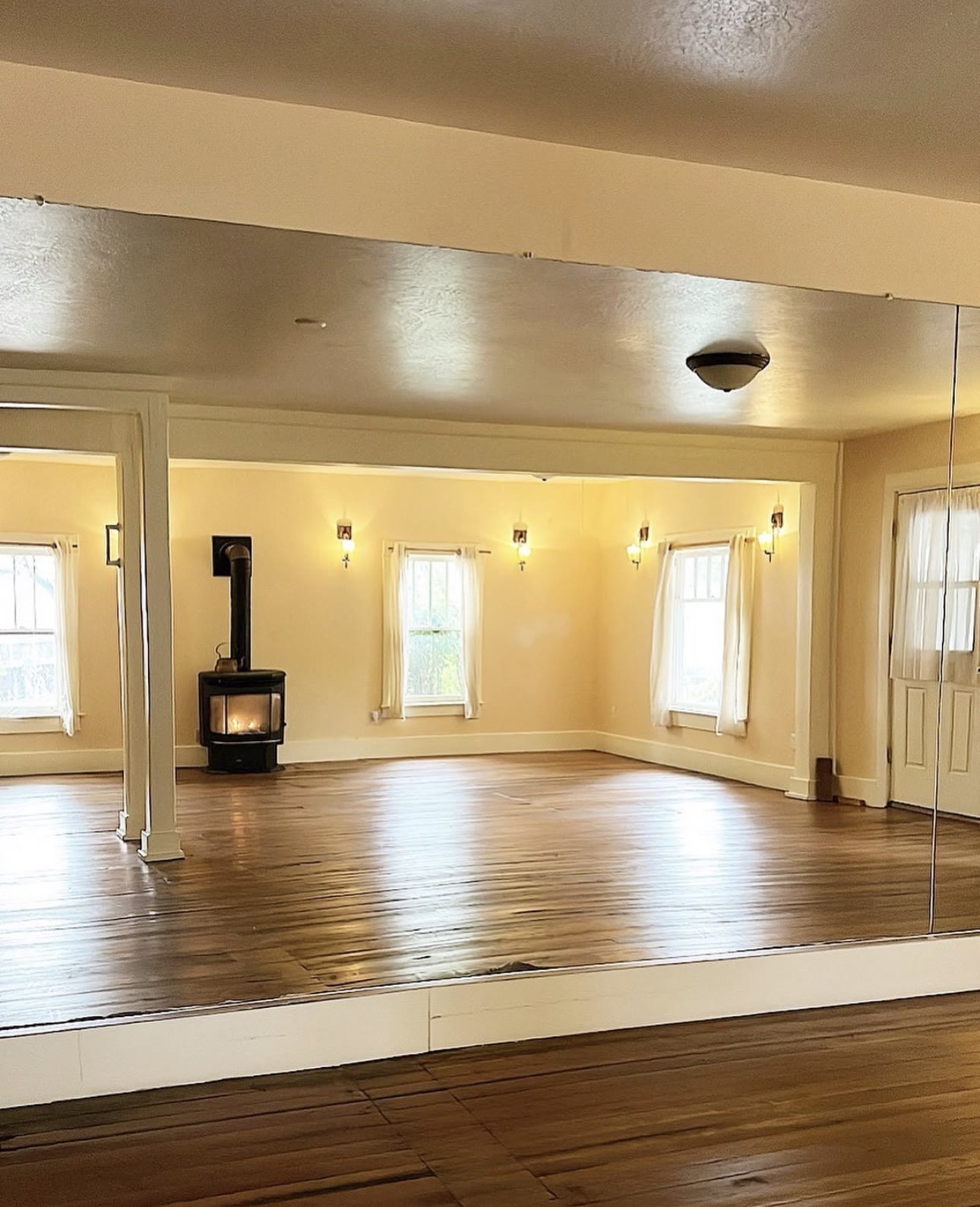 The fireplace and windows reflected in the studio's mirror wall