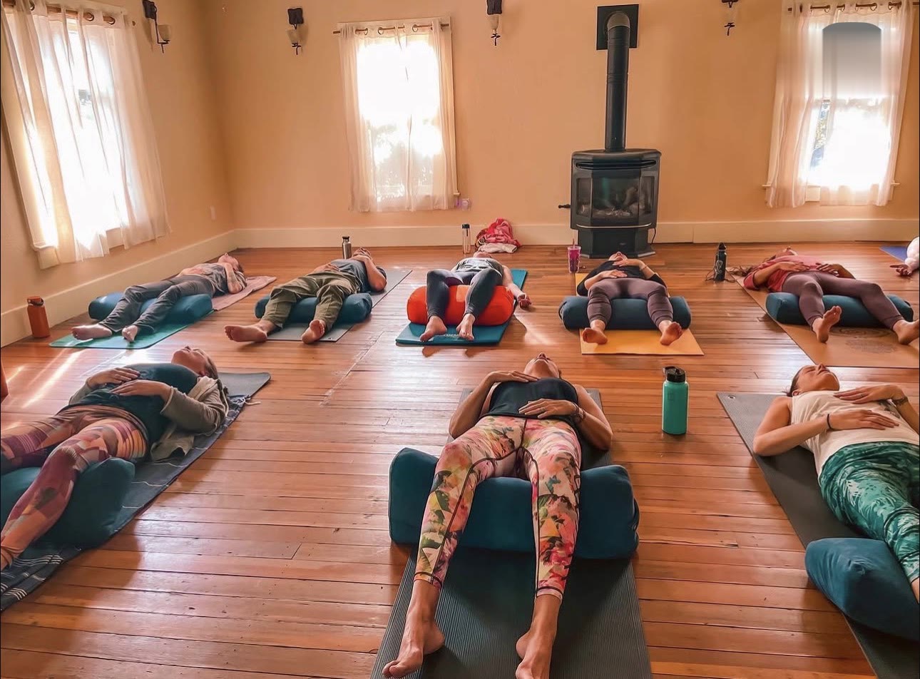 A restorative class resting on bolsters by the fire